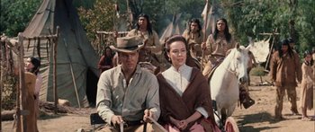 Movie still from “Flaming Star” (1960), directed by Don Siegel – A man and a woman sitting next to each other on a field; Medium shot, Over the shoulder angle