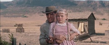Movie still from “Flaming Star” (1960), directed by Don Siegel – A man and a little girl holding guns in a field; Medium shot, Low angle