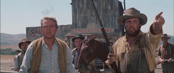 Movie still from “Flaming Star” (1960), directed by Don Siegel – A group of men standing next to a horse; Medium shot, Low angle