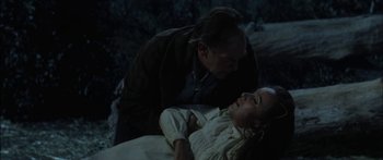 Movie still from “Flaming Star” (1960), directed by Don Siegel – A man and a woman are laying on the ground; Medium shot, High angle