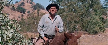 Movie still from “Flaming Star” (1960), directed by Don Siegel – An older man wearing a cowboy hat on a horse; Medium shot, Low angle