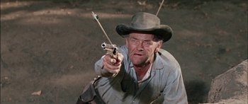 Movie still from “Flaming Star” (1960), directed by Don Siegel – A man in a cowboy hat holding two guns; Medium shot, Low angle