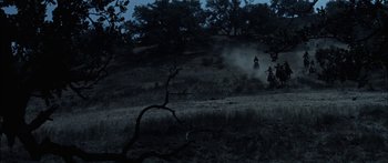Movie still from “Flaming Star” (1960), directed by Don Siegel – Two people riding horses through a field at night; Extreme Wide shot, High angle