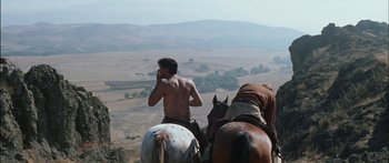 Movie still from “Flaming Star” (1960), directed by Don Siegel – A man on a horse talking on a cell phone; Wide shot, Low angle