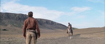 Movie still from “Flaming Star” (1960), directed by Don Siegel – A man riding a horse in the middle of the desert; Wide shot, Low angle