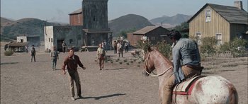 Movie still from “Flaming Star” (1960), directed by Don Siegel – A group of people riding horses in a dirt field; Extreme Wide shot, Low angle