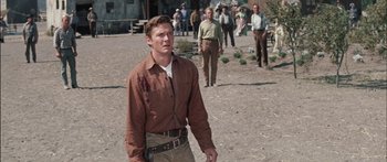 Movie still from “Flaming Star” (1960), directed by Don Siegel – A group of men standing in the dirt; Medium shot, Low angle