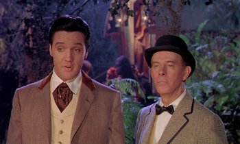 Movie still from “Frankie and Johnny” (1966), directed by Frederick De Cordova – A couple of men standing next to each other in suits; Medium shot, Over the shoulder angle