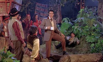 Movie still from “Frankie and Johnny” (1966), directed by Frederick De Cordova – A group of people sitting in a forest; Wide shot, Low angle