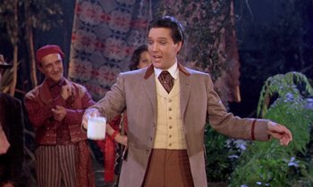 Movie still from “Frankie and Johnny” (1966), directed by Frederick De Cordova – A man in a suit and tie holding a cup; Medium shot, Over the shoulder angle