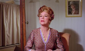 Movie still from “Frankie and Johnny” (1966), directed by Frederick De Cordova – An older woman sitting in a chair wearing a dress; Medium shot, Low angle