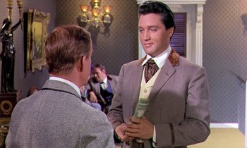 Movie still from “Frankie and Johnny” (1966), directed by Frederick De Cordova – A man in a suit and tie talking to another man in a suit and tie; Medium shot, Over the shoulder angle