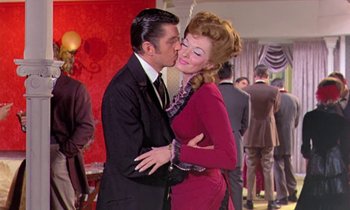 Movie still from “Frankie and Johnny” (1966), directed by Frederick De Cordova – A man and a woman kissing each other in front of a crowd; Medium shot, Over the shoulder angle