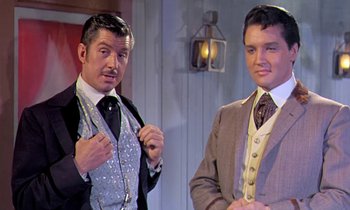 Movie still from “Frankie and Johnny” (1966), directed by Frederick De Cordova – A couple of men standing next to each other in suits; Medium shot, Low angle