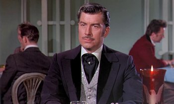 Movie still from “Frankie and Johnny” (1966), directed by Frederick De Cordova – A man in a suit sitting at a table; Close Up shot, Low angle