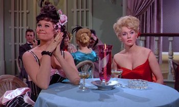 Movie still from “Frankie and Johnny” (1966), directed by Frederick De Cordova – A group of women sitting at a dinner table; Medium shot, Low angle