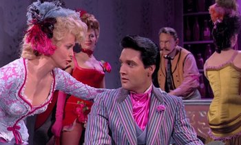 Movie still from “Frankie and Johnny” (1966), directed by Frederick De Cordova – A man in a pink suit is sitting next to a woman in a pink dress; Medium shot, Over the shoulder angle