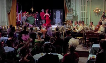 Movie still from “Frankie and Johnny” (1966), directed by Frederick De Cordova – A group of people sitting and standing on a stage; Wide shot, High angle