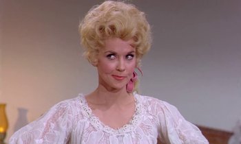 Movie still from “Frankie and Johnny” (1966), directed by Frederick De Cordova – A woman in a white dress and pink earrings; Close Up shot, Low angle