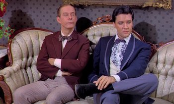 Movie still from “Frankie and Johnny” (1966), directed by Frederick De Cordova – A couple of men sitting on top of a couch; Medium shot, Low angle