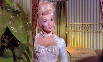 Movie still from “Frankie and Johnny” (1966), directed by Frederick De Cordova – A woman in a white dress with a bow in her hair; Medium shot, Low angle