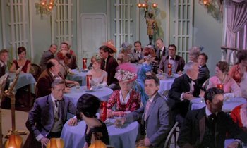 Movie still from “Frankie and Johnny” (1966), directed by Frederick De Cordova – A group of people sitting at a table with purple tablecloths; Wide shot, High angle