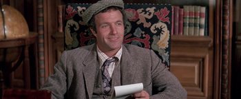 Movie still from “Funny Lady” (1975), directed by Herbert Ross – A man sitting on top of a chair holding a piece of paper; Close Up shot, High angle