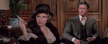 Movie still from “Funny Lady” (1975), directed by Herbert Ross – A woman wearing a hat and a fur coat sitting next to a man; Close Up shot, High angle
