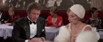 Movie still from “Funny Lady” (1975), directed by Herbert Ross – A man and a woman sitting at a dinner table; Close Up shot, Over the shoulder angle