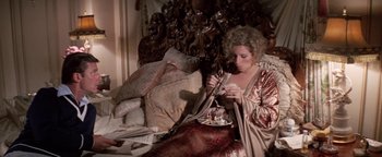 Movie still from “Funny Lady” (1975), directed by Herbert Ross – A woman sitting on a bed with a plate of food in front of her face; Medium shot, High angle