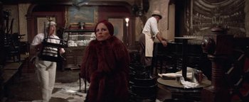 Movie still from “Funny Lady” (1975), directed by Herbert Ross – A woman in a red fur coat and a man in a red hat; Wide shot, Over the shoulder angle