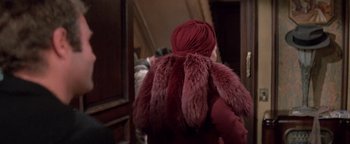 Movie still from “Funny Lady” (1975), directed by Herbert Ross – A woman wearing a red coat and a red turban; Medium shot, Over the shoulder angle