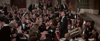 Movie still from “Funny Lady” (1975), directed by Herbert Ross – A crowd of people sitting and standing in a room; Wide shot, High angle