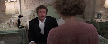 Movie still from “Funny Lady” (1975), directed by Herbert Ross – A man sitting in front of a woman in front of a mirror; Medium shot, Over the shoulder angle