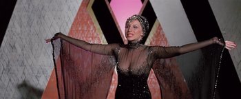 Movie still from “Funny Lady” (1975), directed by Herbert Ross – A woman wearing a black dress and a head scarf; Medium shot, Low angle