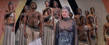 Movie still from “Funny Lady” (1975), directed by Herbert Ross – A group of men and a woman standing next to each other; Medium shot, Over the shoulder angle