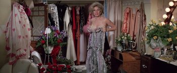 Movie still from “Funny Lady” (1975), directed by Herbert Ross – A woman in a dress in a room full of clothes; Medium shot, High angle