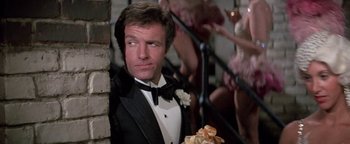 Movie still from “Funny Lady” (1975), directed by Herbert Ross – A man in a tuxedo standing next to a brick wall; Close Up shot, Low angle