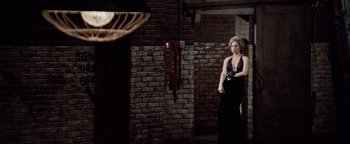 Movie still from “Funny Lady” (1975), directed by Herbert Ross – A woman in a black dress standing next to a brick wall; Wide shot, Low angle