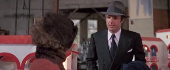 Movie still from “Funny Lady” (1975), directed by Herbert Ross – A man wearing a suit and a hat standing next to a woman; Close Up shot, Over the shoulder angle