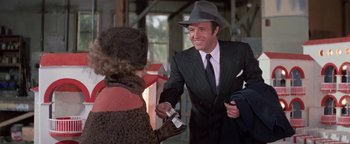 Movie still from “Funny Lady” (1975), directed by Herbert Ross – A man in a suit and hat shaking a woman's hand; Medium shot, Over the shoulder angle