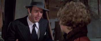 Movie still from “Funny Lady” (1975), directed by Herbert Ross – A man wearing a suit and a hat talking to a woman; Close Up shot, Over the shoulder angle