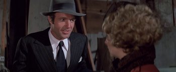 Movie still from “Funny Lady” (1975), directed by Herbert Ross – A man wearing a suit and a hat talking to a woman; Close Up shot, Over the shoulder angle