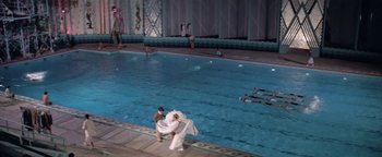 Movie still from “Funny Lady” (1975), directed by Herbert Ross – A man and a woman in wedding dresses in a swimming pool; Extreme Wide shot, High angle