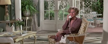 Movie still from “Funny Lady” (1975), directed by Herbert Ross – A woman sitting on a chair talking on a phone; Medium shot, High angle
