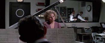 Movie still from “Funny Lady” (1975), directed by Herbert Ross – A woman sitting in front of a grand piano in a room; Medium shot, Over the shoulder angle