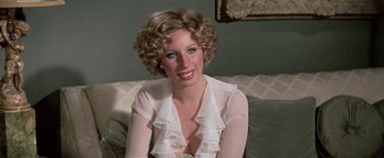 Movie still from “Funny Lady” (1975), directed by Herbert Ross – A woman in a white blouse sitting on a couch; Close Up shot, High angle