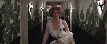 Movie still from “Funny Lady” (1975), directed by Herbert Ross – A woman in a white blouse is walking down a hall way; Medium shot, Over the shoulder angle