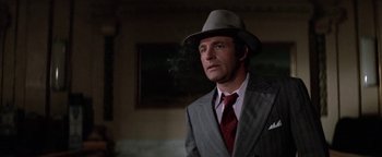 Movie still from “Funny Lady” (1975), directed by Herbert Ross – A man in a suit and hat smoking a cigarette; Close Up shot, Low angle