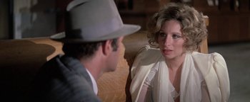 Movie still from “Funny Lady” (1975), directed by Herbert Ross – A man and a woman sitting next to each other on a couch; Close Up shot, Over the shoulder angle